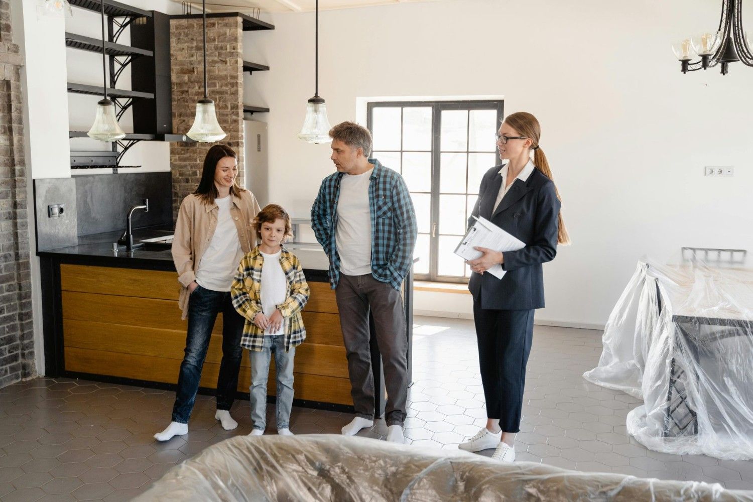 Family exploring a newly purchased home interior with real estate agent.